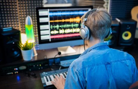 rear-view-of-young-man-in-headphones-making-music-QD29FZR-460×295.jpg